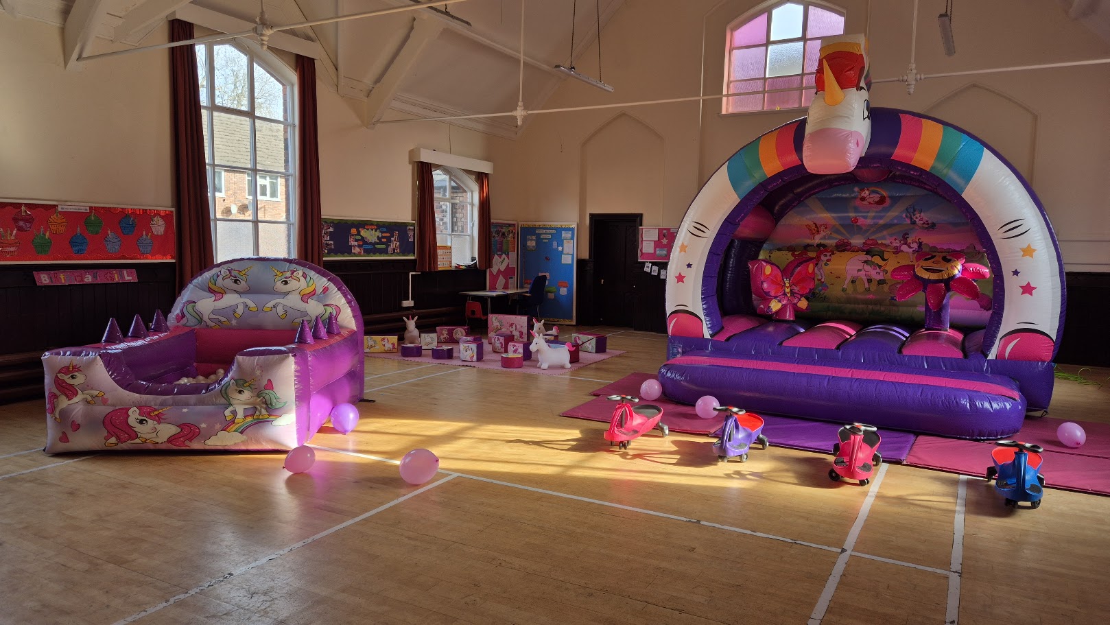 Indoor unicorn bouncy castle and soft play setup in Stockport hall