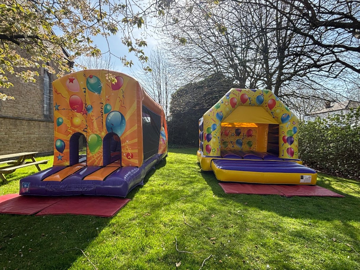 Large balloon-themed inflatable obstacle course and bouncy castle setup at a venue in Heaton Moor, SK4.